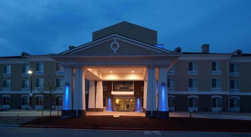 a large building with blue columns in front of it at Holiday Inn Express Hotel & Suites Lamar By IHG in Lamar