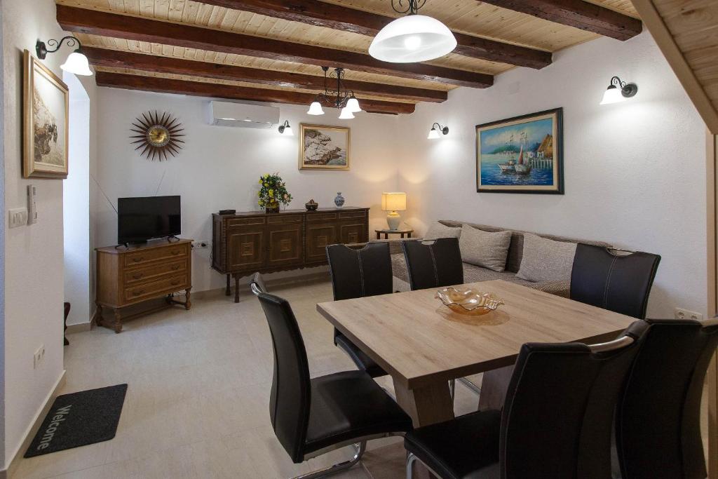 a dining room with a table and chairs at Holiday Home NiKa in Omišalj