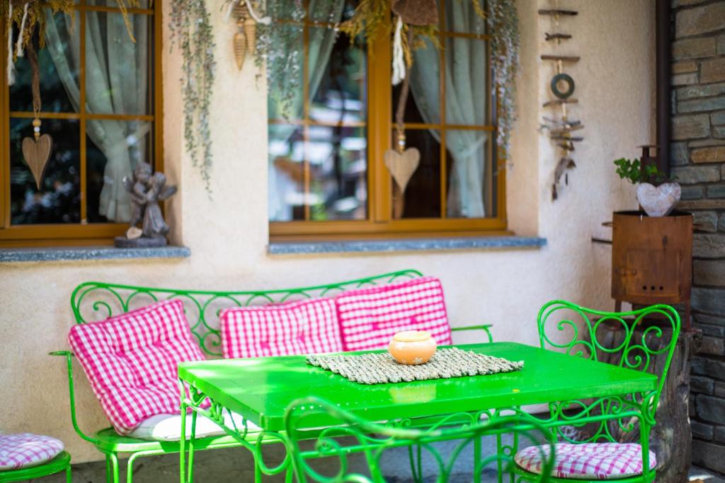 a green table and chairs on a patio at Hotel Romantica in Zermatt
