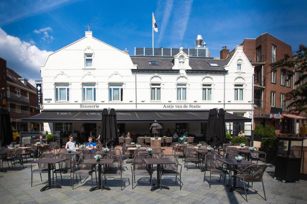 un grupo de mesas y sillas frente a un edificio en Brasserie-Hotel Antje van de Statie, en Weert
