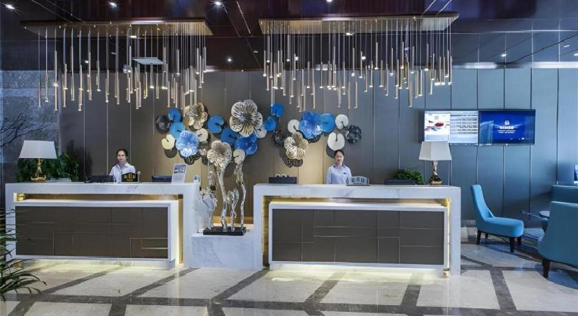 a lobby with two people sitting at a reception desk at Metropolo Hotel Yining Development Zone Hanma Building in Yining Airport