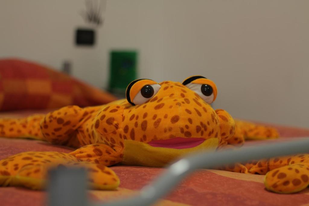 einem ausgestopften Frosch auf einem Bett in der Unterkunft Elicrim in Santo Stefano di Magra