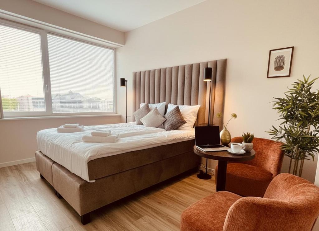a bedroom with a bed and a laptop on a table at Chic Suite W Bathroom & Kitchen in Geertruidenberg