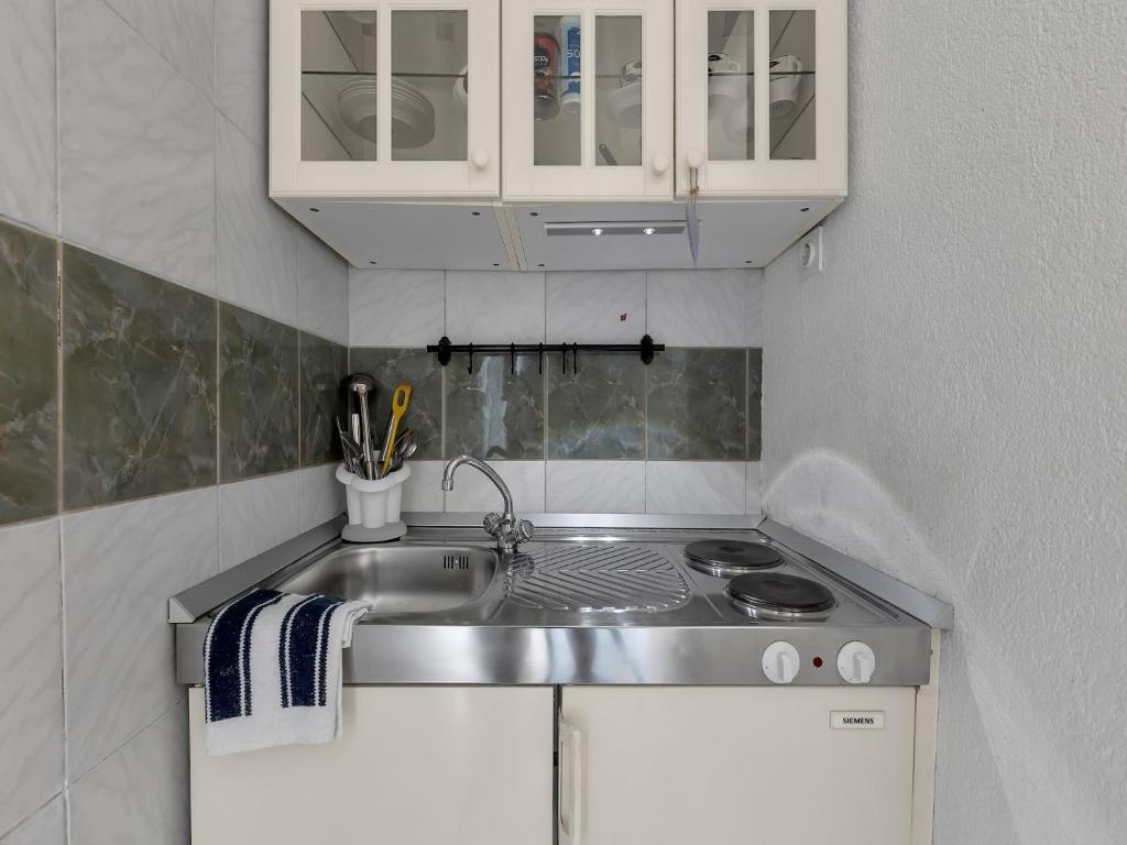 a small kitchen with a sink and a stove at Apartments Kata - Studio Apartment in Makarska
