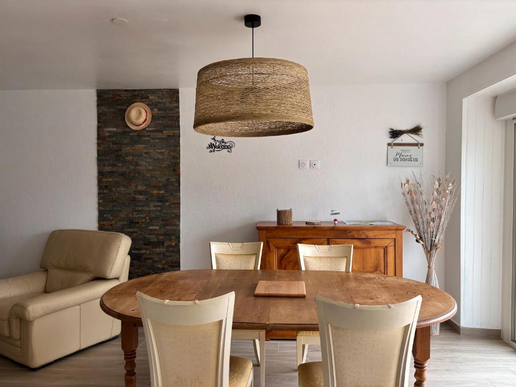 a dining room with a wooden table and chairs at Gite en Brocéliande avec vue in Néant-sur-Yvel