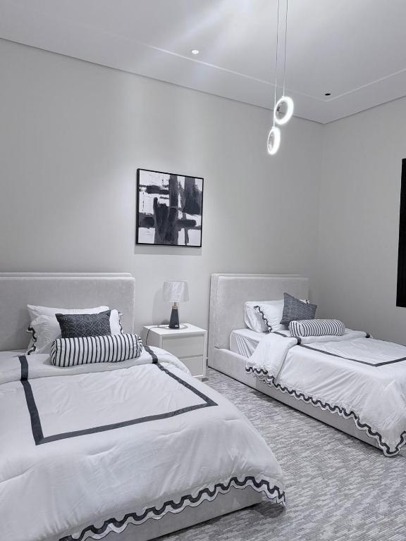 哈伊勒منتجع دارك的卧室设有2张床和白色的墙壁。