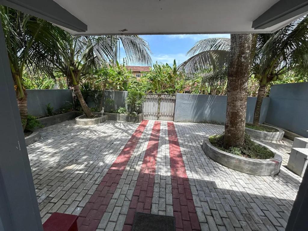 a courtyard with palm trees and a brick floor at MJ Villa Ahangama in Ahangama