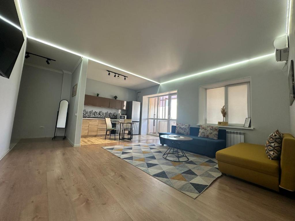 una sala de estar con un sofá y una mesa en Уютная и комфортная 3х комнатная в новом центре, en Uralsk