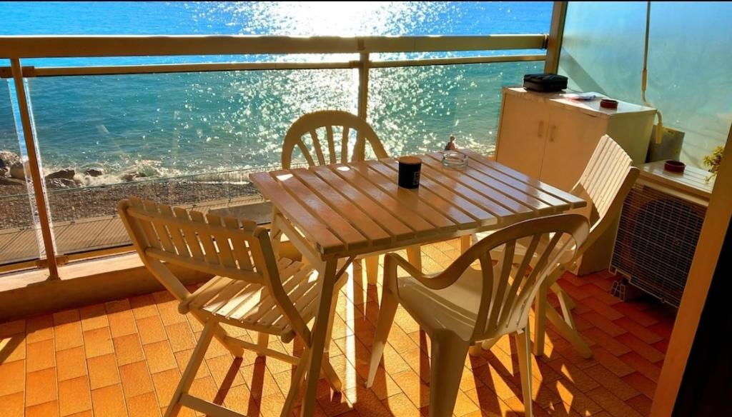 - une table en bois avec deux chaises et une vue sur l'océan dans l'établissement Fronte mare-Free parking-ideale inverno-wi fi, à Menton