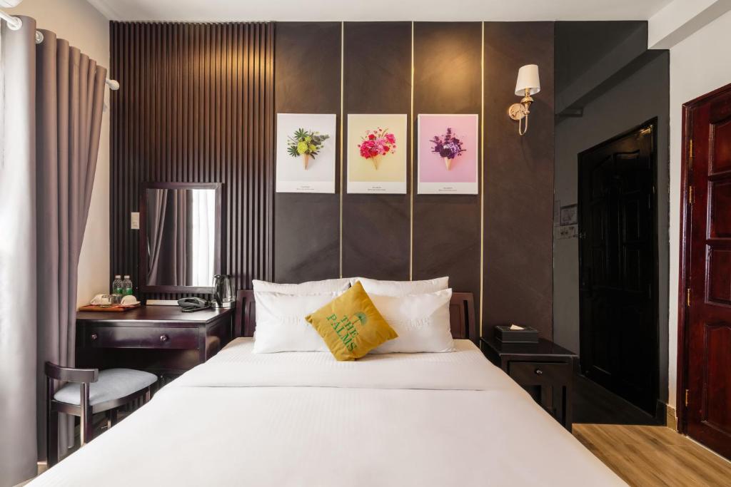 Un dormitorio con una gran cama blanca y un escritorio. en The Palms Hotel Phan Thiết, en Phan Thiet