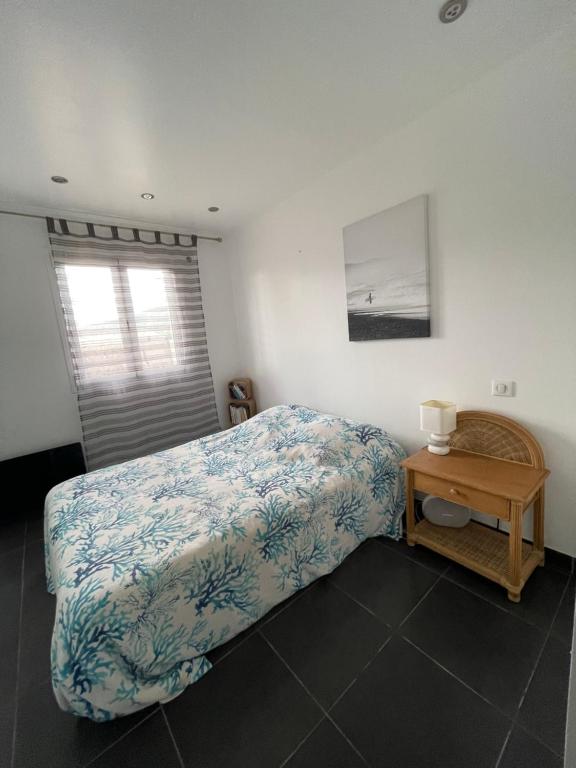 a bedroom with a bed and a table and a window at Bord de mer in Sainte-Maxime