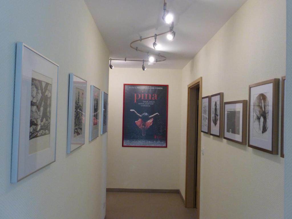 a hallway with a bunch of pictures on the walls at K-Haus Sankt Aldegund in Sankt Aldegund