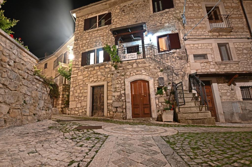 een oud stenen gebouw met een deur en een balkon bij Le Dimore di Angelo in SantʼEufemia a Maiella