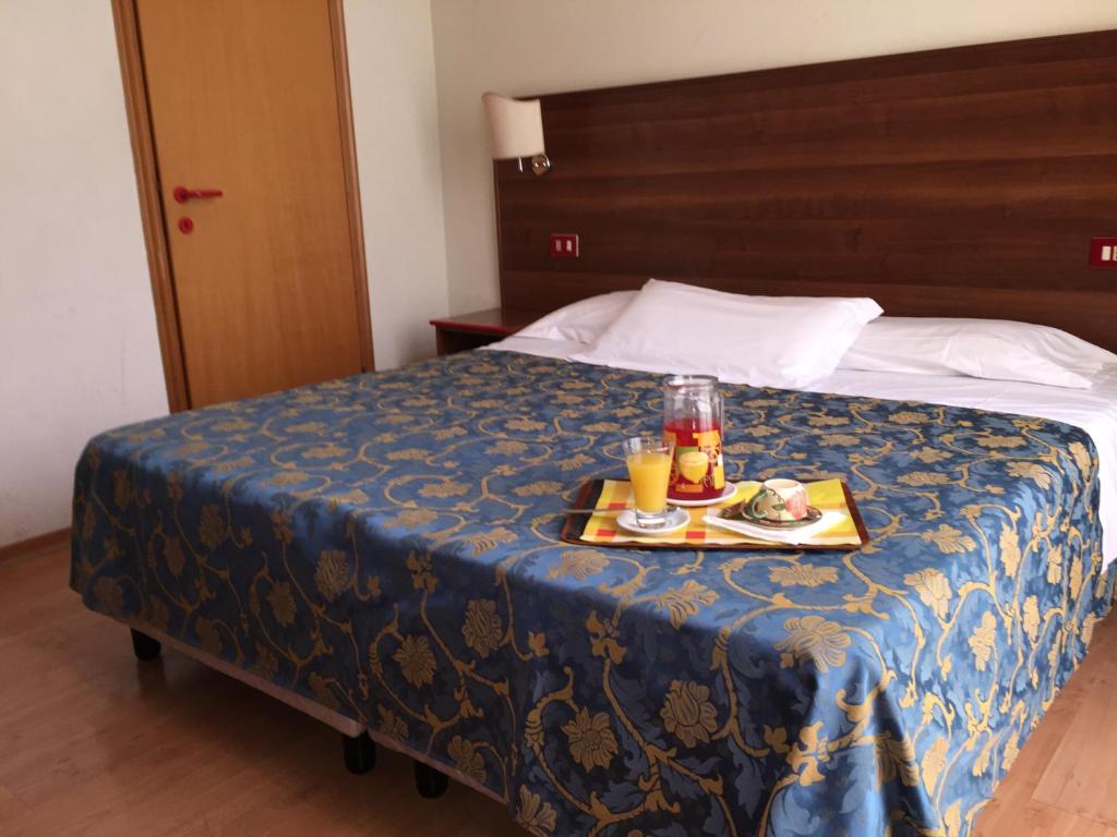 una camera d'albergo con un vassoio di cibo su un letto di Hotel Altavilla Dieci a Roma
