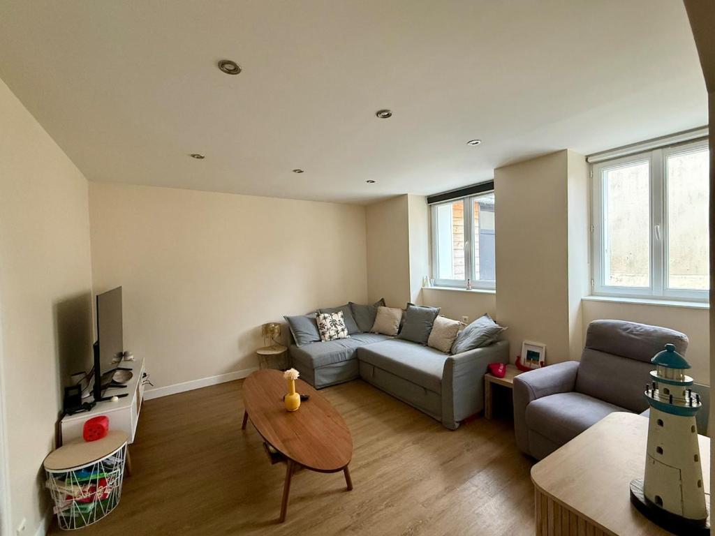 a living room with a couch and a table at L'escale Granvillaise in Granville