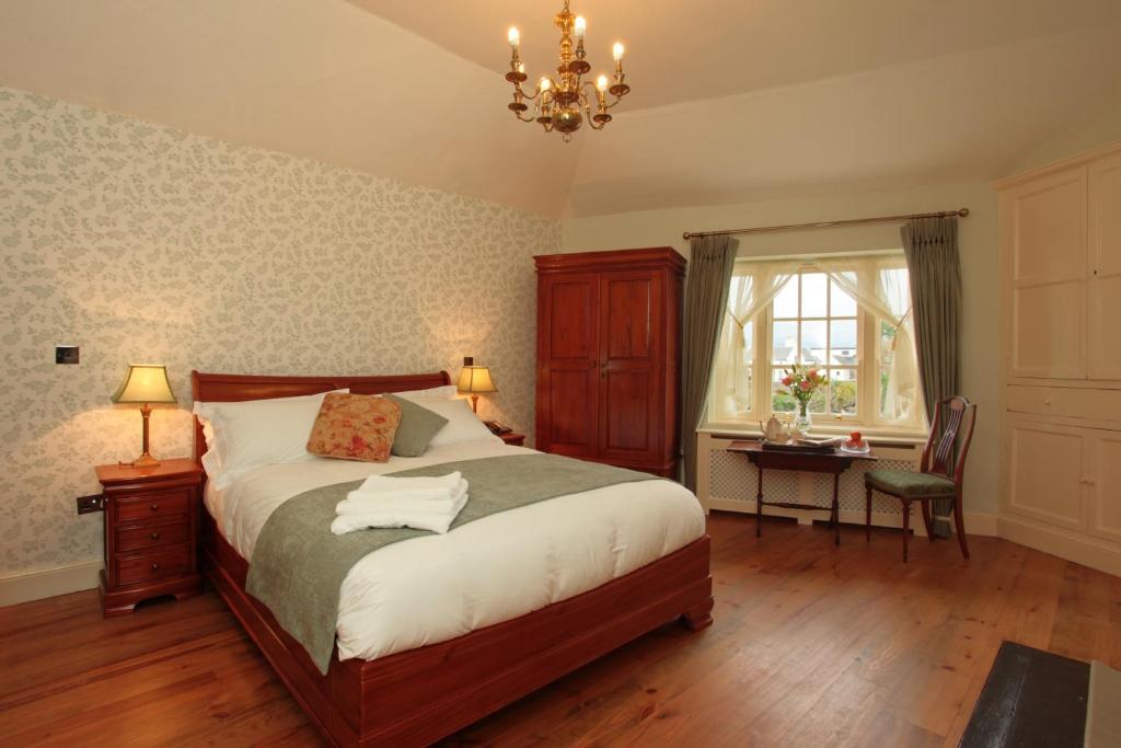 a bedroom with a bed and a desk and a chandelier at Corrib House Guest Accommodation in Galway