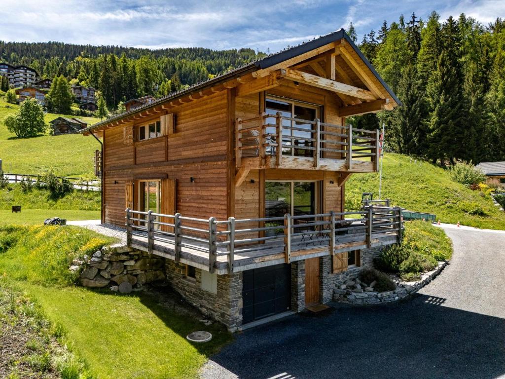 a log house on a hill with a balcony at Chalet Panaga in La Tzoumaz