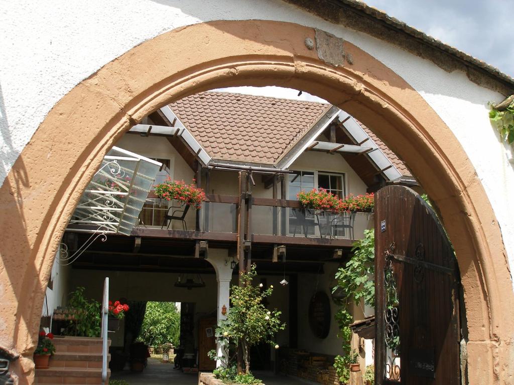 une arche menant à une maison avec des boîtes de fleurs dans l'établissement Gästehaus im Malerwinkel-Rhodt, à Rhodt unter Rietburg