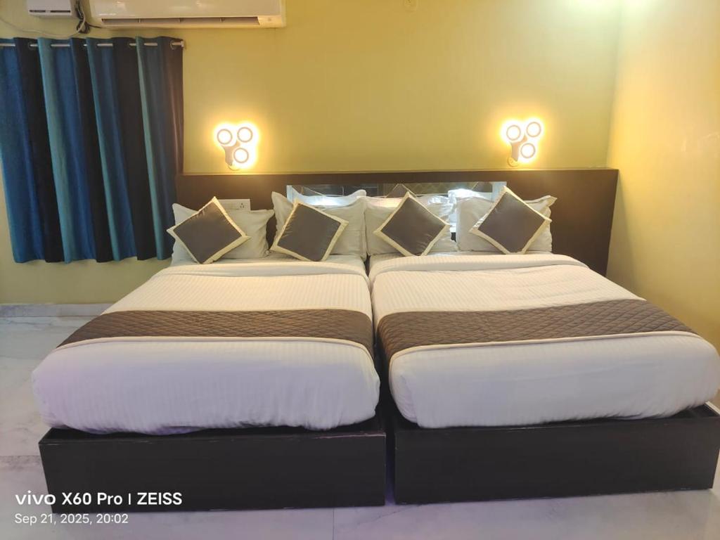 two beds sitting next to each other in a bedroom at bangalore residency in Srikalahasti