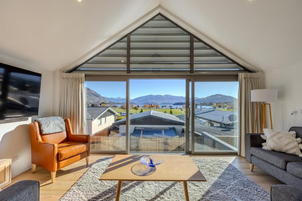 Una sala de estar con un gran ventanal con vistas. en Aspiring View Apartments, en Wanaka