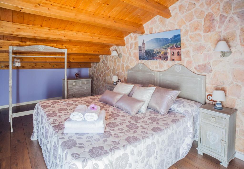1 dormitorio con 1 cama con 2 toallas en Apartamentos Rurales Millan, en La Mata de los Olmos