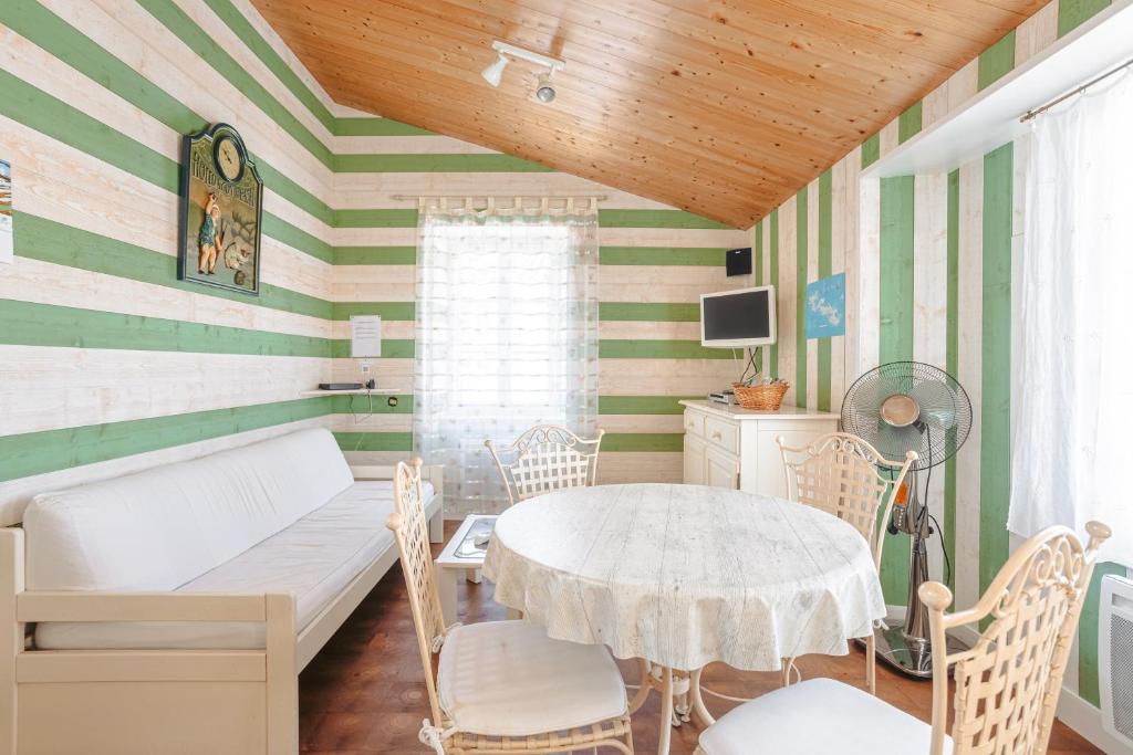 a room with green and white striped walls and a table at Appartement Ars-en-Ré Heraudeau in Ars-en-Ré