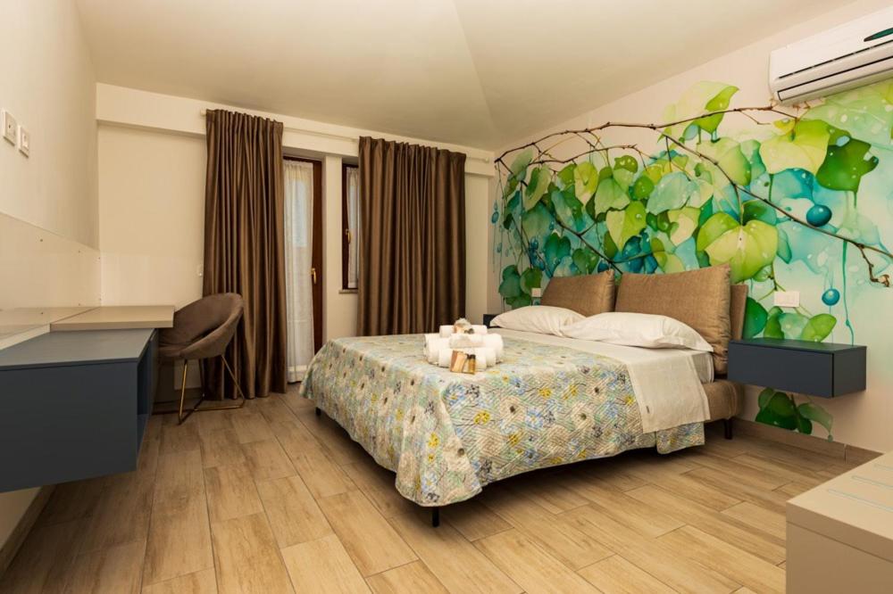 a bedroom with a bed with a painting on the wall at Il Nido dei Merli in Fiumicino