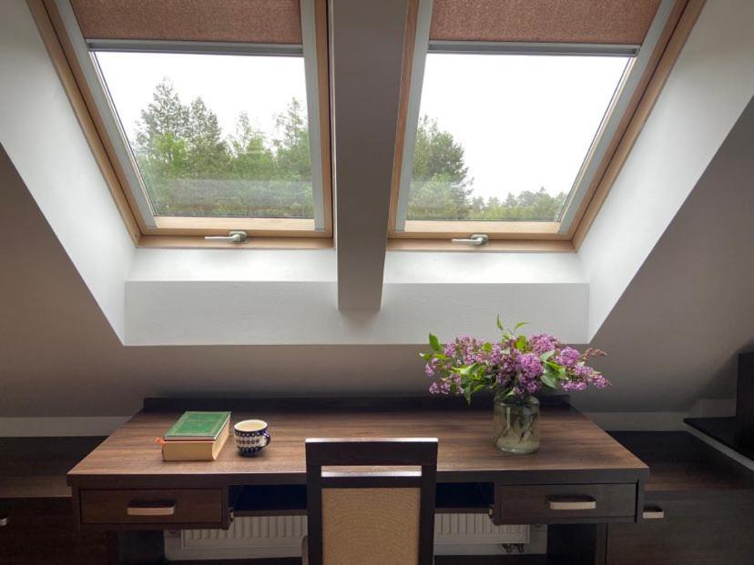 にあるAgroturystyka Kruszynaの花と本が置かれたテーブルのある部屋