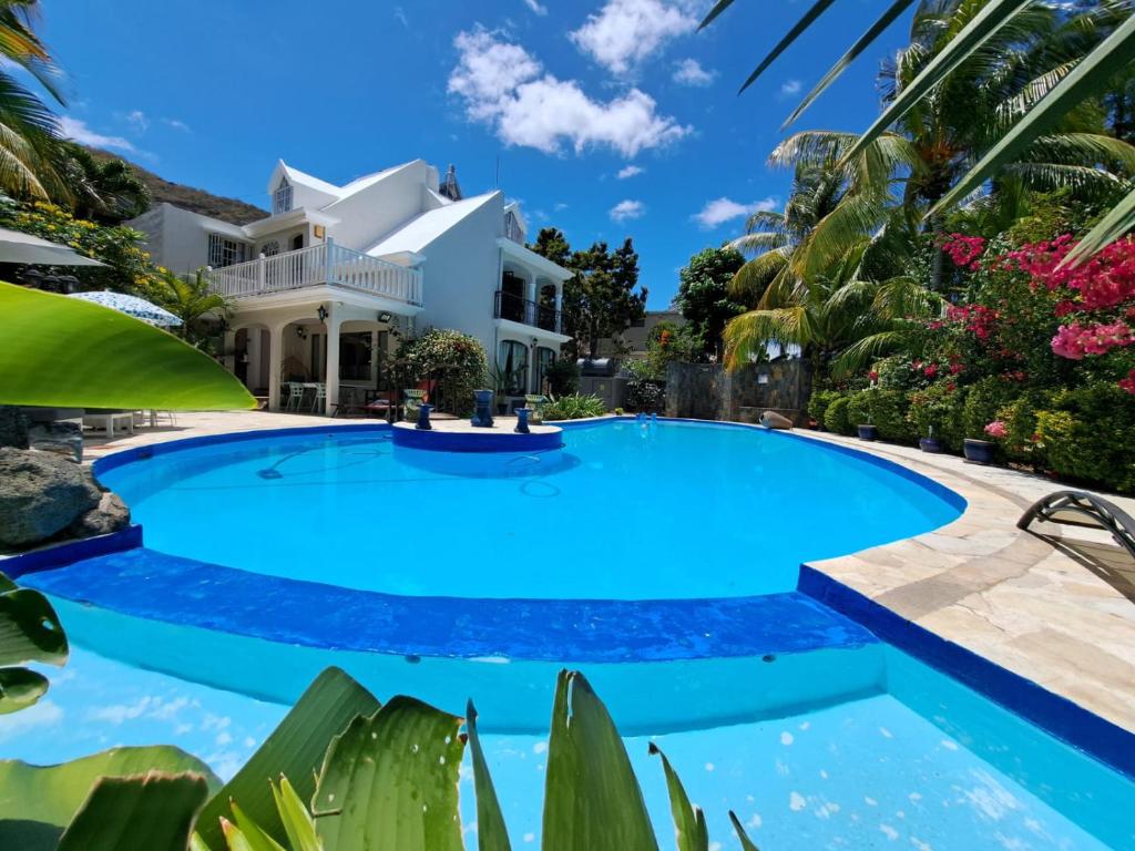 a large swimming pool in front of a house at Villa Tourelle of Paradise with bigPrivate Pool in Rivière Noire