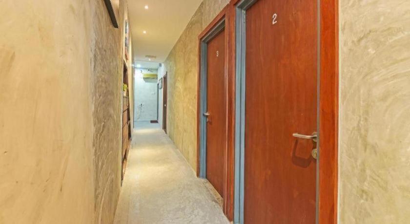 un couloir vide avec une porte en bois et un couloir dans l'établissement OYO 90662 The 1975 Hotel, à Kampong Bukit Ubi
