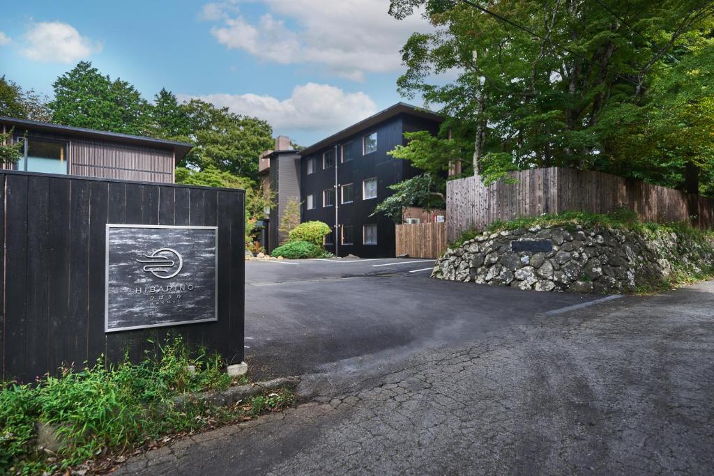 a sign on the side of a road with a building at Hakone Hibarino in Hakone