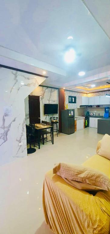 a bedroom with a bed and a kitchen with a table at Vel Serene Villa in Panglao Island