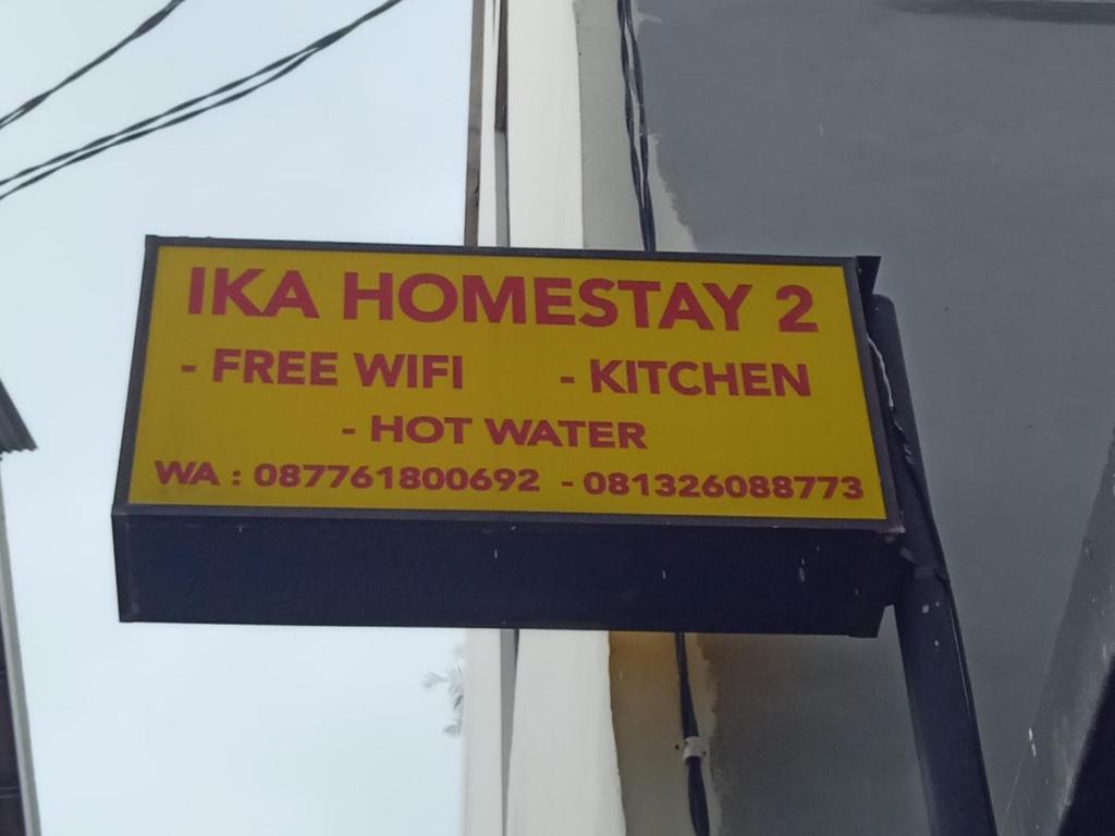 a yellow sign on the side of a building at Ika Homestay 2 in Canggu