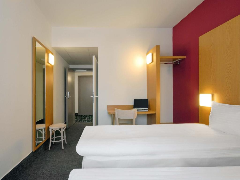 a hotel room with a large bed and a desk at B&B Hotel Prague City in Prague