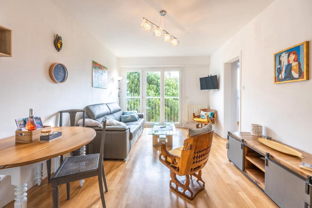 una sala de estar con una mesa y un sofá en Appartement 4 Pièces, 3 Chambres, en Les Sables-dʼOlonne