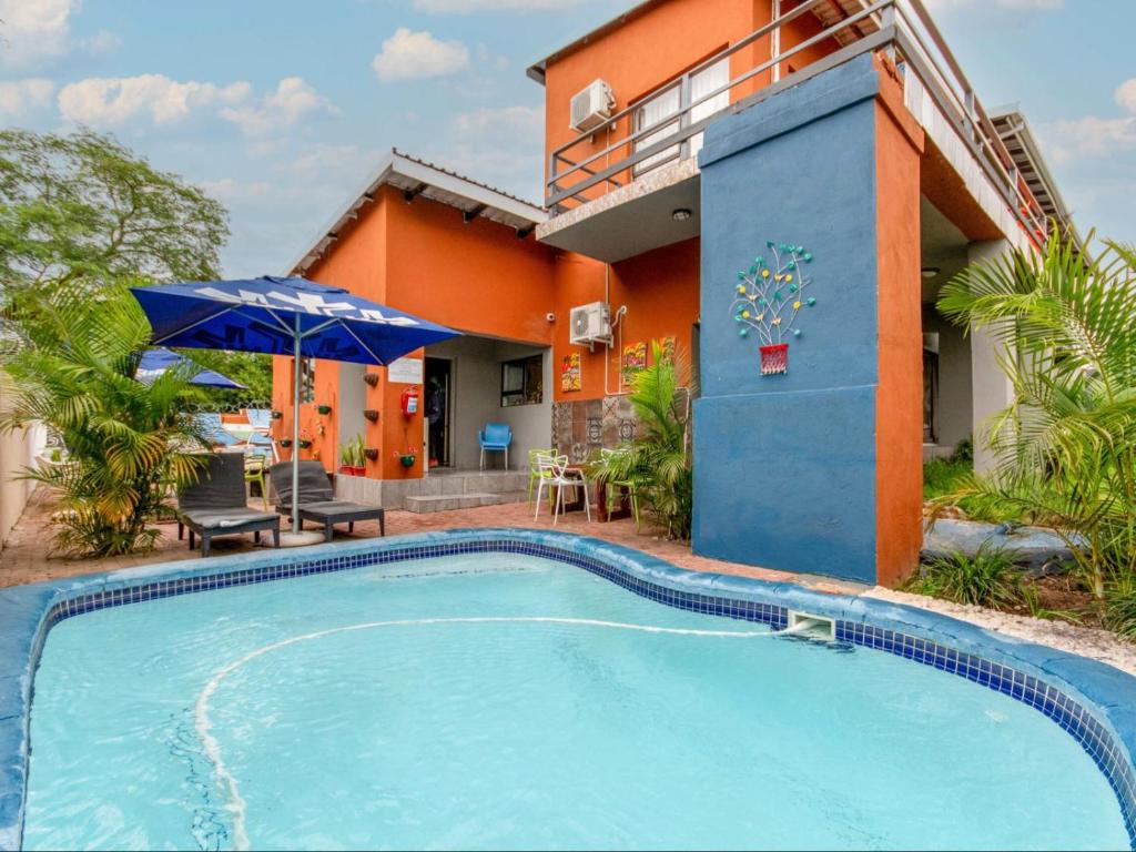 a house with a swimming pool in front of a house at Woodpecker's Guest House in Hazyview