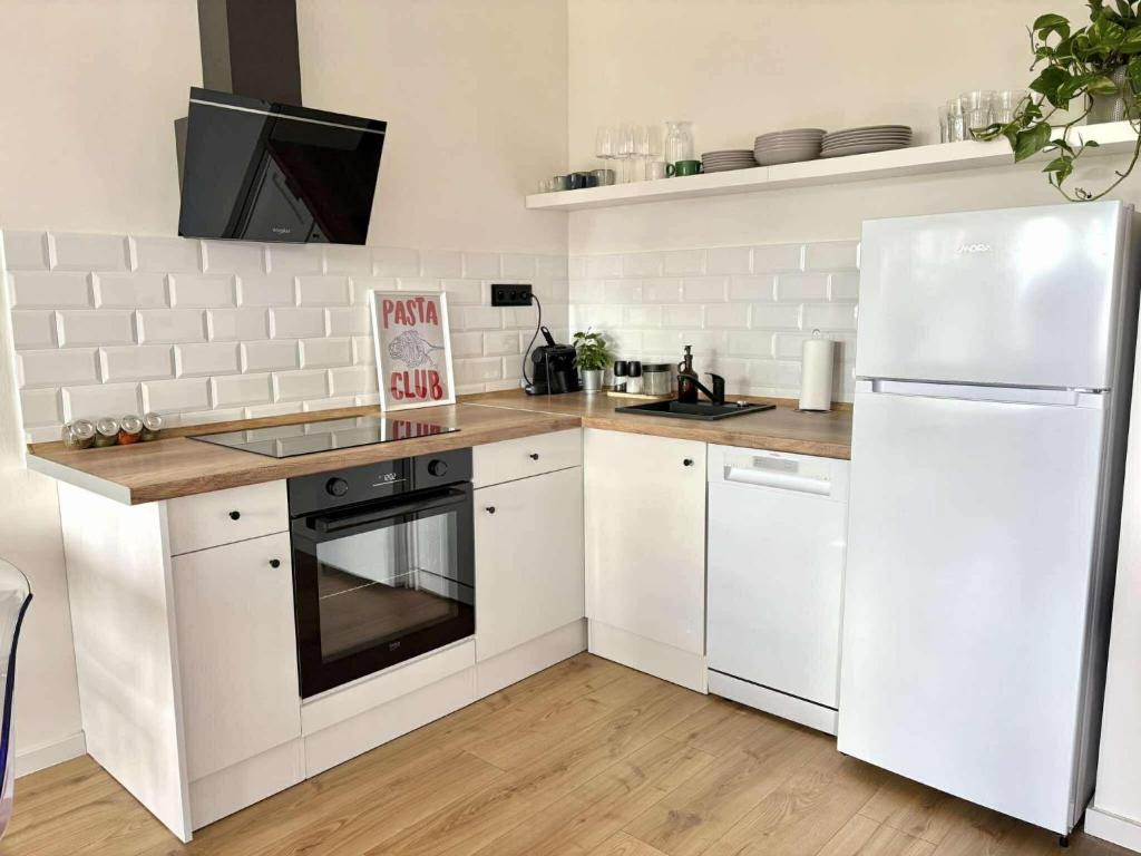 a kitchen with white cabinets and a white refrigerator at Krivoo Apartments III in Košice