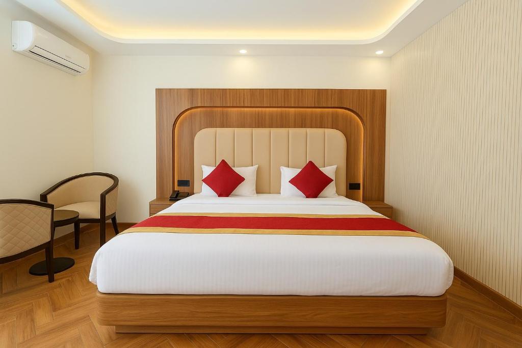 um quarto com uma cama grande com travesseiros vermelhos em OPO Essential SKYNEX em Nova Deli