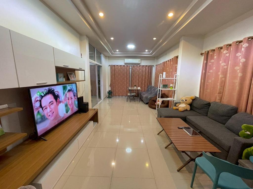 a living room with a couch and a flat screen tv at Cozy House in the center of Khon Kaen in Khon Kaen