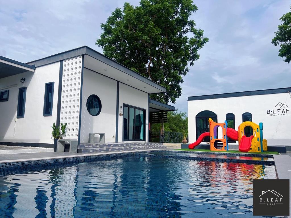 a house with a swimming pool and a playground at B.leaf in Ban Hup Kaphong