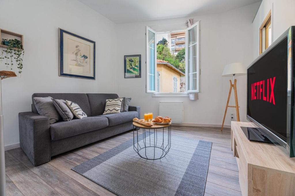 Una sala de estar con un sofá y un televisor en Le Coq Albert II - Monaco border - WiFi, en Beausoleil