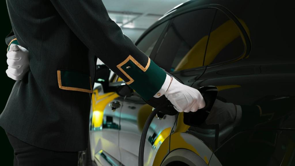 a man is opening the door of a car at Hotel Bristol in Oslo