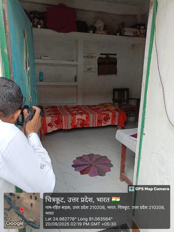 een man die een foto neemt van een bed in een kamer bij Kuldeep Mishra Rural Homestay in Karwi