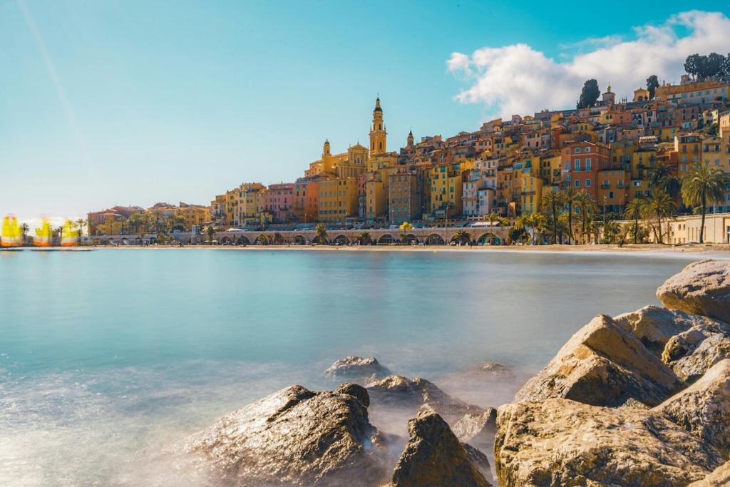 - une vue sur une plage avec une ville en arrière-plan dans l'établissement Le Coq Casamare - Air conditioning - WiFi - New - Sea, à Menton