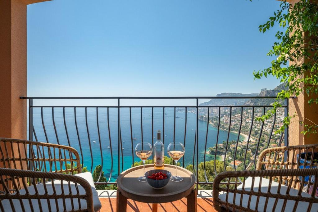 ein Tisch mit zwei Gläsern Wein auf einem Balkon in der Unterkunft Le COQ Grace Kelly - Parking - AC - Amazing view in Roquebrune-Cap-Martin