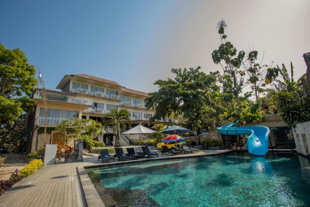 a swimming pool with a slide and a playground at The Tanis Beach Resort Nusa Lembongan in Nusa Lembongan