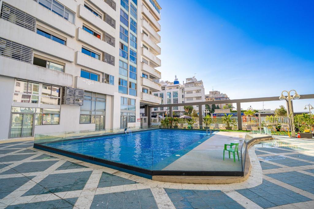 une piscine devant un immeuble dans l'établissement Jolie appt avec Balcon - Hypercentre, proche Medina et Plage, à Tanger
