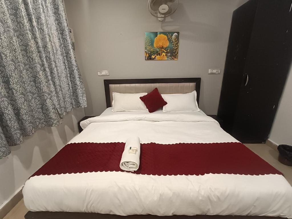 een bed met een rode en witte deken erop bij Hotel Stay Inn in Noida
