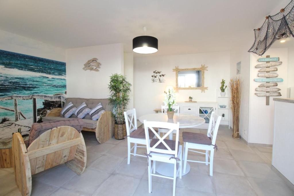a kitchen and living room with a table and chairs at Gite La Paillotte, Ile De Ré in Sainte-Marie-de-Ré