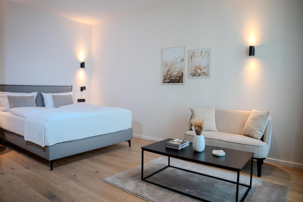 a bedroom with a bed and a couch and a table at The MYDE Hamburg Serviced Apartments in Hamburg